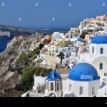 greece-santorini-the-village-of-oia-and-its-houses-with-whitewashed-walls-and-blue-domes-on-the-cliff-overlooking-the-caldera